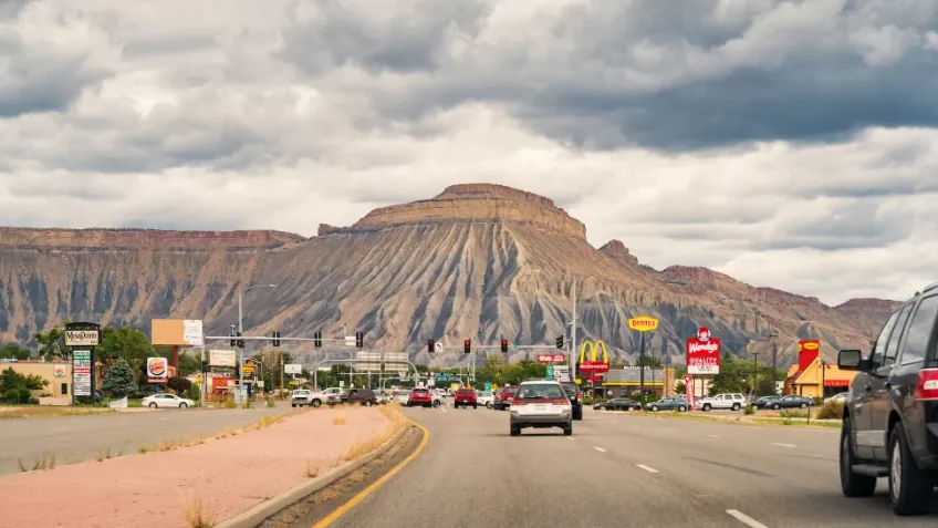 Highway 6 through Clifton, Colorado, with Mount Garfield ahead